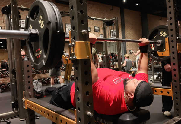 Athlete performing a loaded barbell bench press while using The Launch Pad.