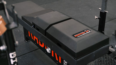 Angled view of The Launch Pad™ on powerlifting bench, showcasing its durable build and firm support for elite strength training, while highlighting its compatibility with professional gym equipment.