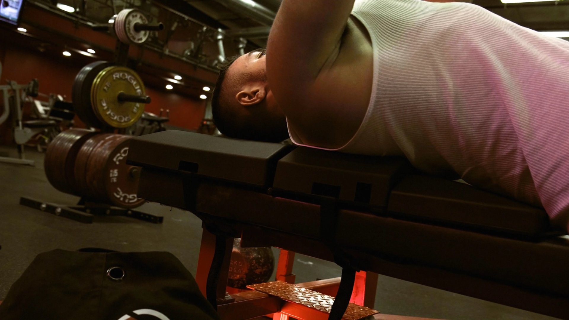 Close-up of an athlete performing a dumbbell bench press using The Launch Pad, designed to enhance form, strength, and performance.