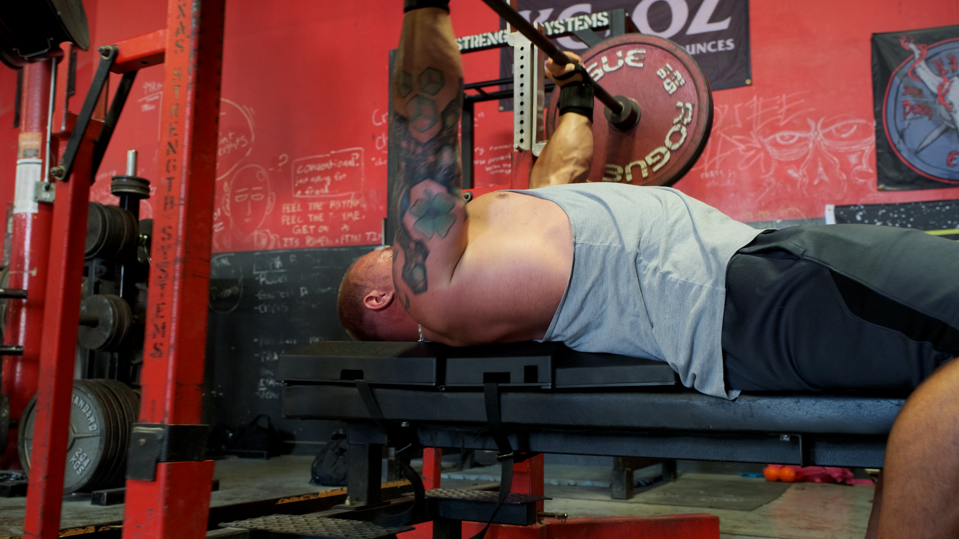 Athlete performing a bench press with a loaded barbell on The Launch Pad™ demonstrating full lockout position to maximize pressing performance, comfort, and joint alignment.