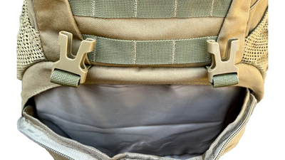 Close-up of the bottom front compartment with buckles on the unbranded tactical backpack, showcasing durable straps and mesh side pockets for versatile storage.