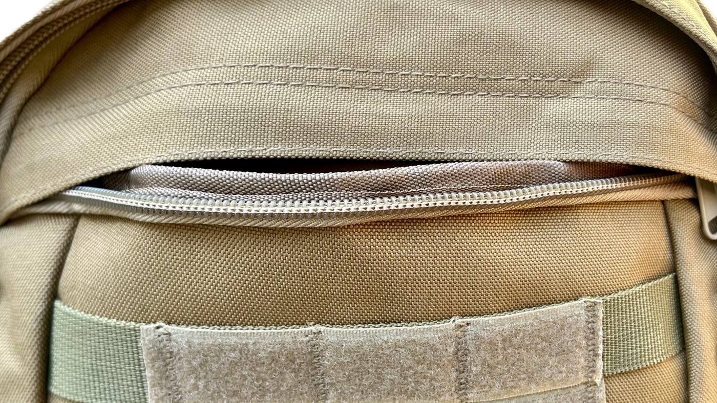 Detailed view of the front zipper pocket on the unbranded tactical backpack, showcasing durable stitching and easy-access storage for secure organization.