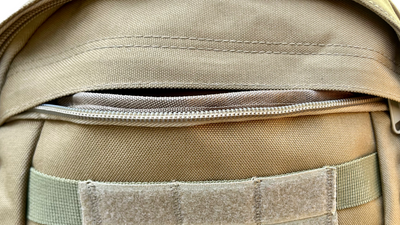 Detailed view of the front zipper pocket on the unbranded tactical backpack, showcasing durable stitching and easy-access storage for secure organization.