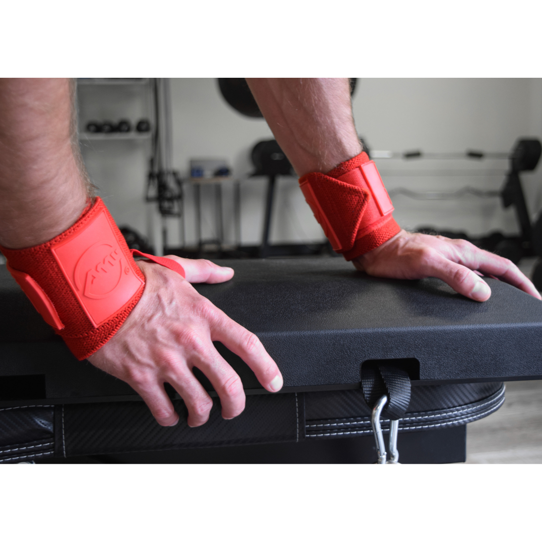 Athlete wearing Advanced Muscle Mechanics Code Red Premium Wrist Wraps for stability and wrist protection while performing a push-up exercise on a bench.