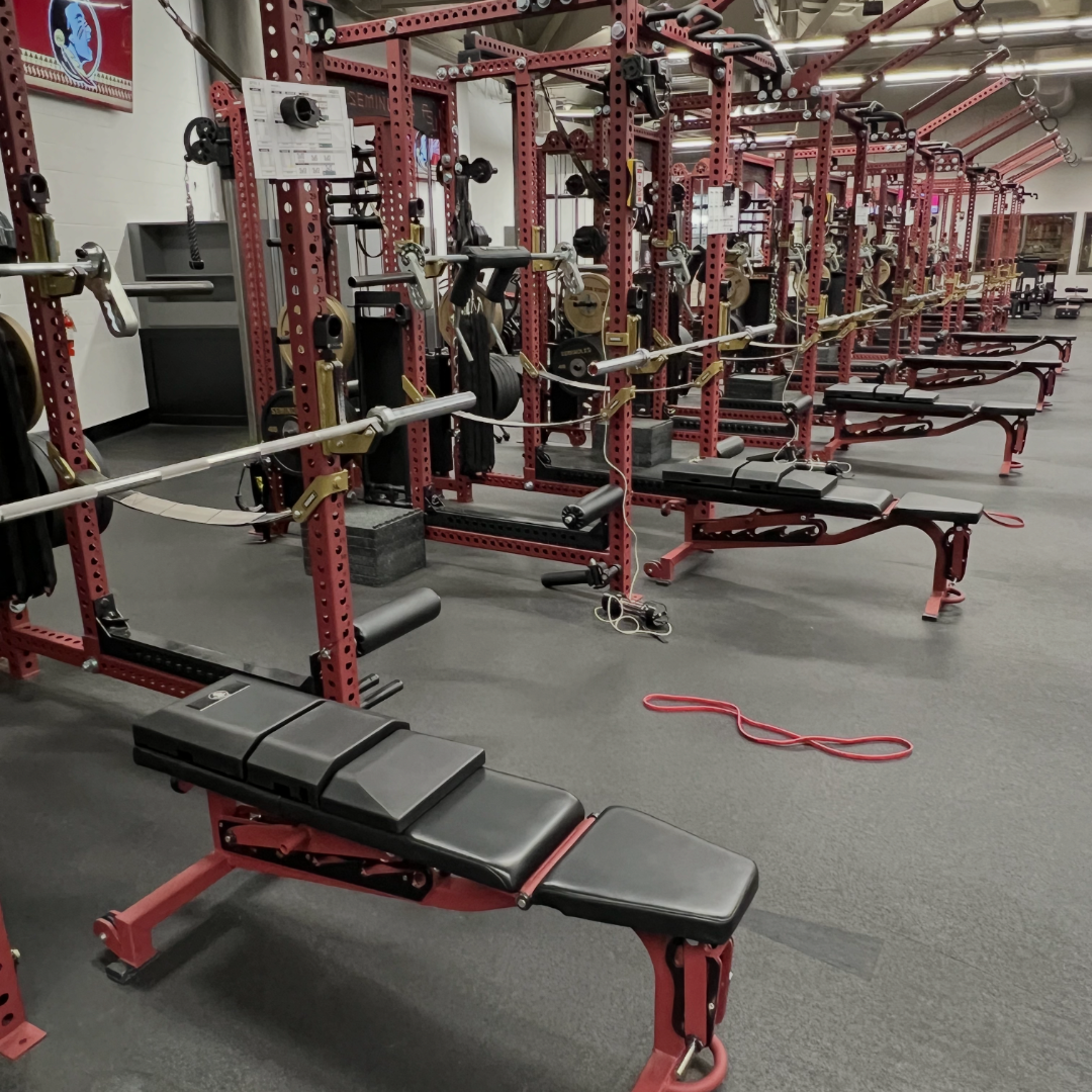 Side view of three benches fitted with custom-branded versions of The Launch Pad® in a weight room.