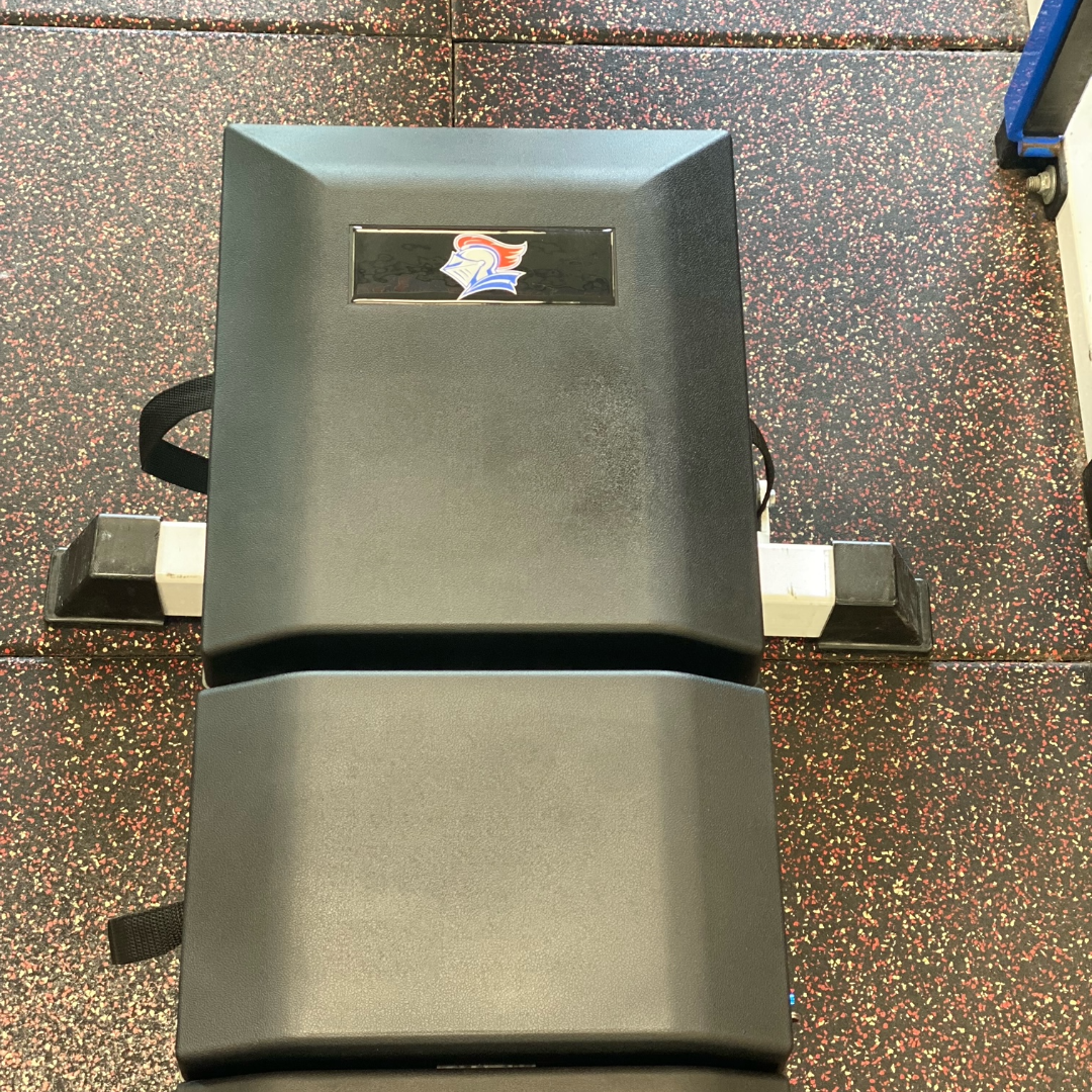 Overhead view of St. Frances Knights custom-branded Launch Pad™ on weight bench, showing contoured ergonomic design for optimal pressing mechanics.