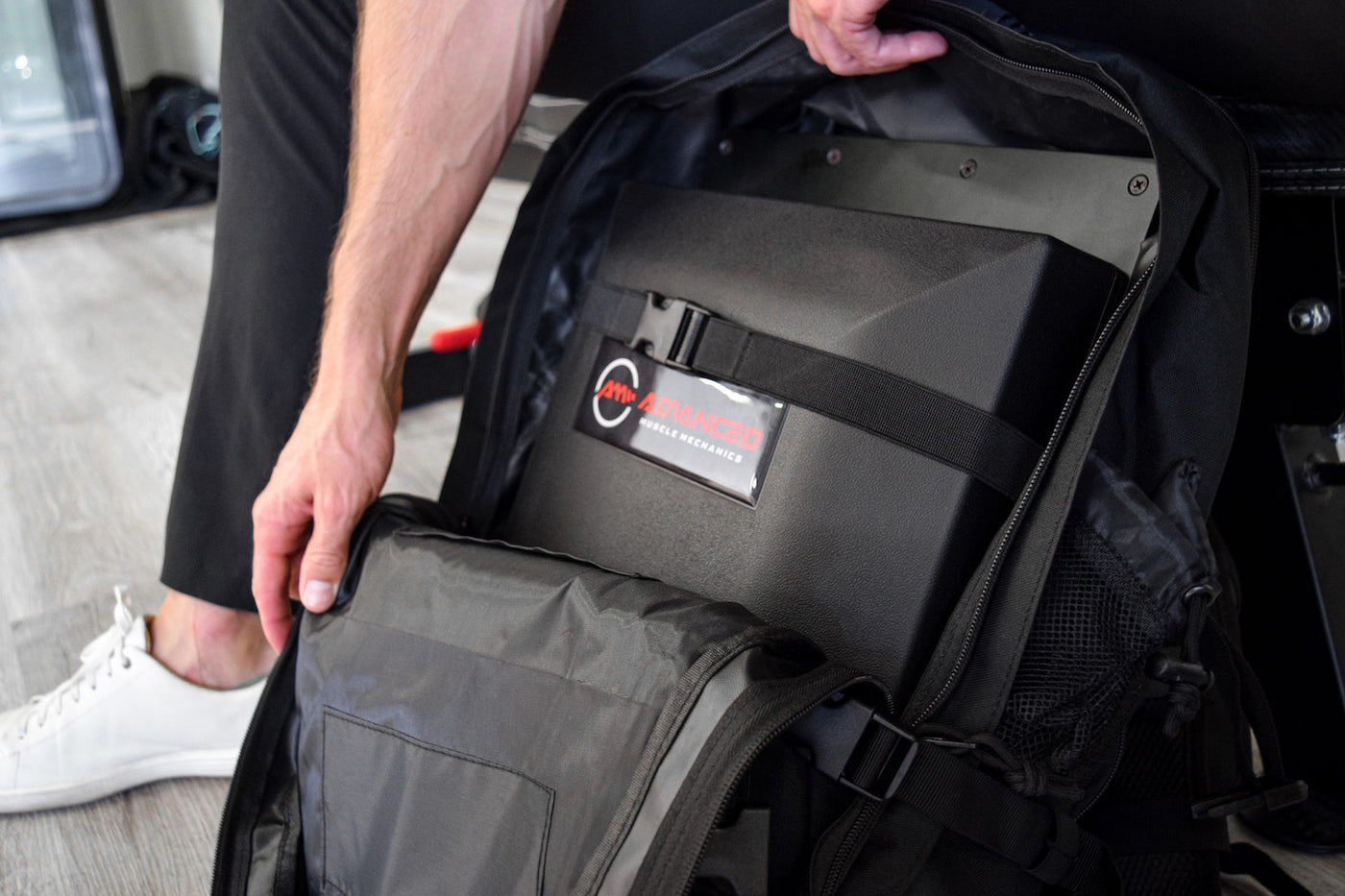 Close-up of The Launch Pad™ strapped inside a tactical backpack, emphasizing secure storage and portability for strength training equipment.