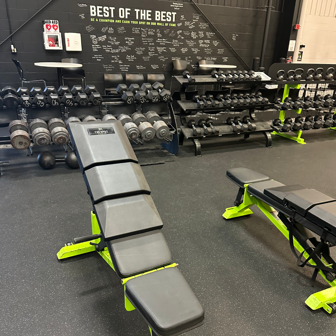 Two adjustable benches at The Spot Athletics equipped with custom Launch Pads™ positioned in front of the facility’s 'Best of the Best' recognition wall.
