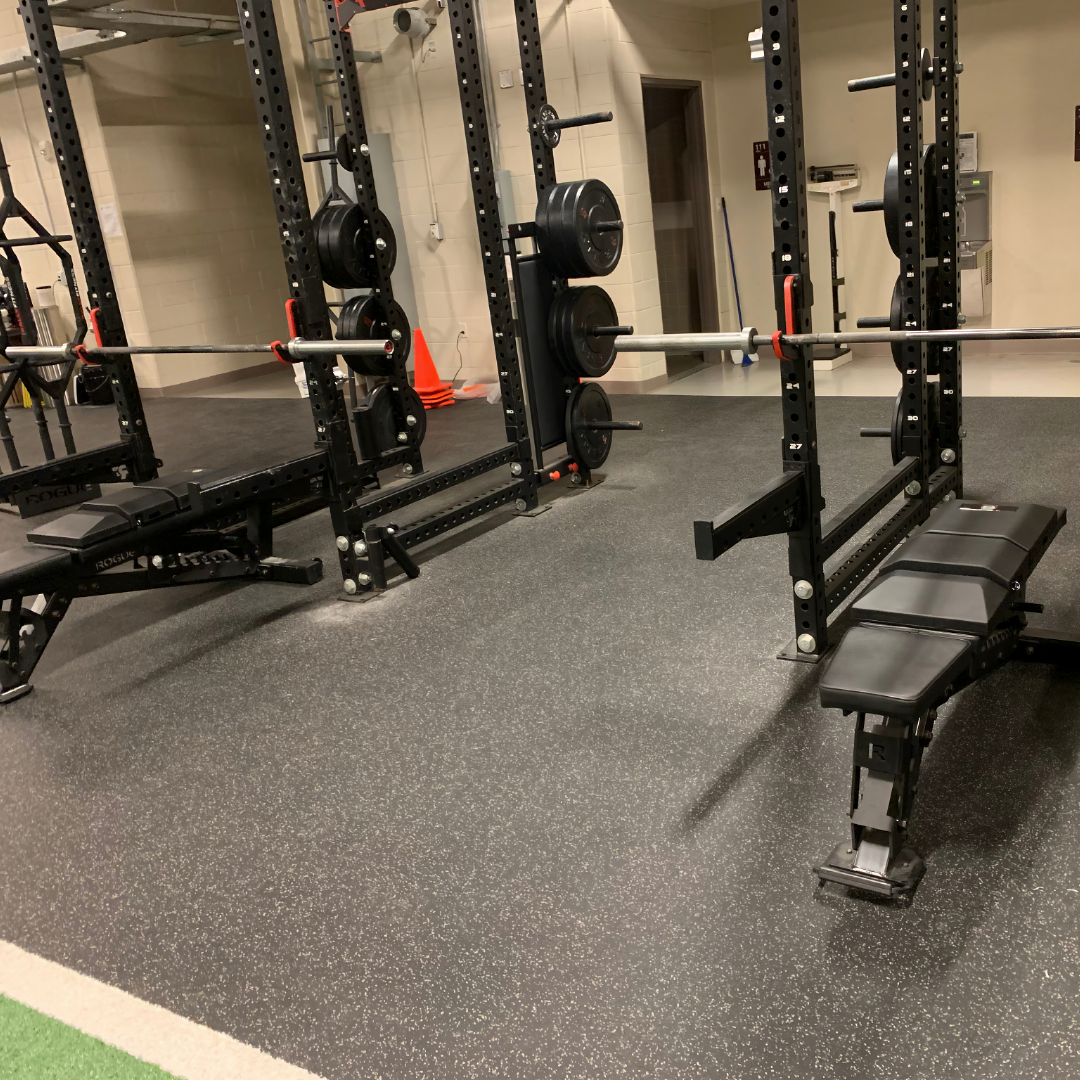 Two benches in black power racks outfitted with USAF TACP custom Launch Pads™ in a tactical strength and conditioning gym.