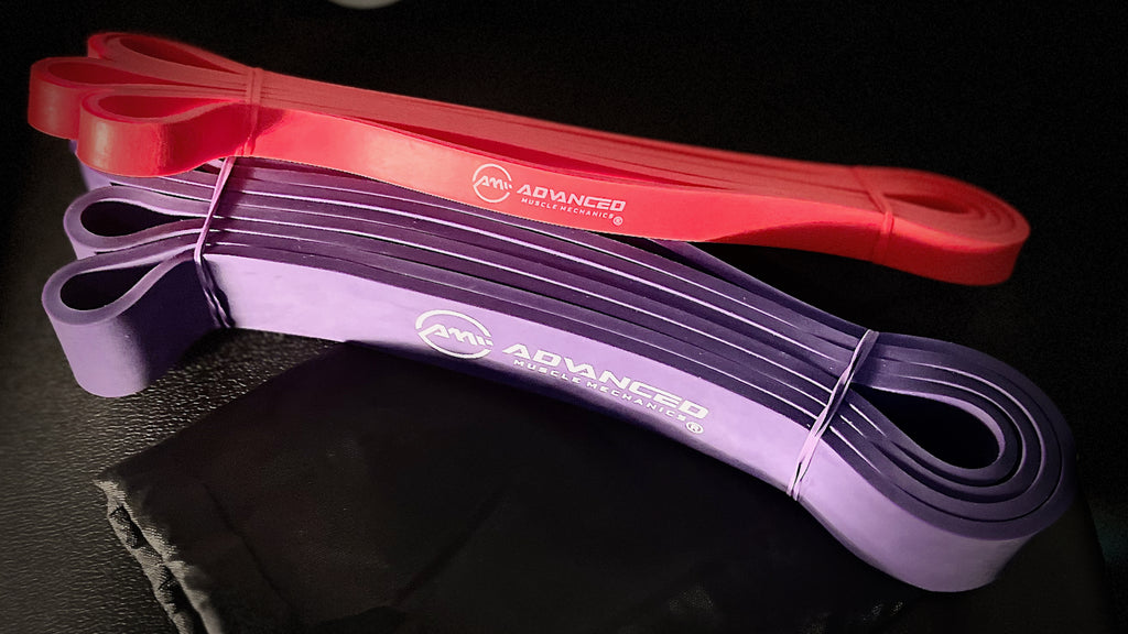 Red and purple Advanced Muscle Mechanics resistance bands for strength training, mobility, and muscle activation exercises.