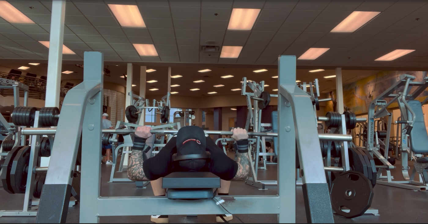 Athlete using The Launch Pad™ during a bench press, ensuring shoulder retraction, depression, and proper joint alignment for safe, effective lifting.