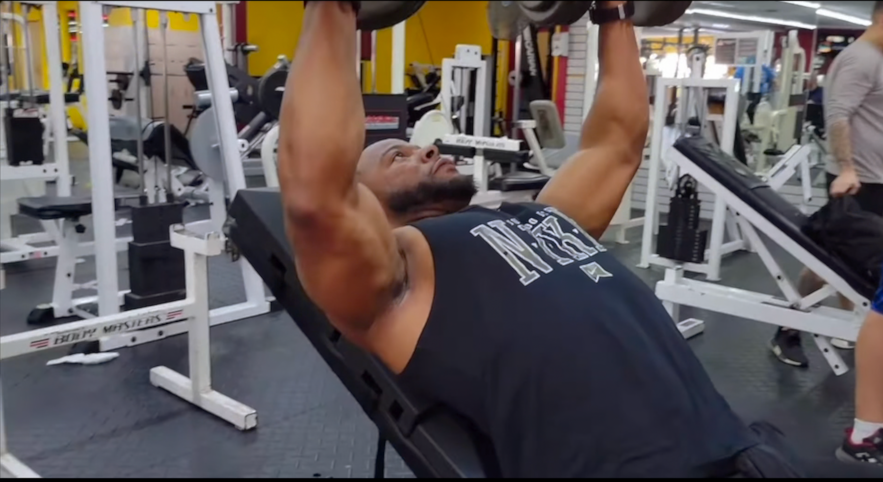 Athlete performing an incline dumbbell press while lying on The Launch Pad®.
